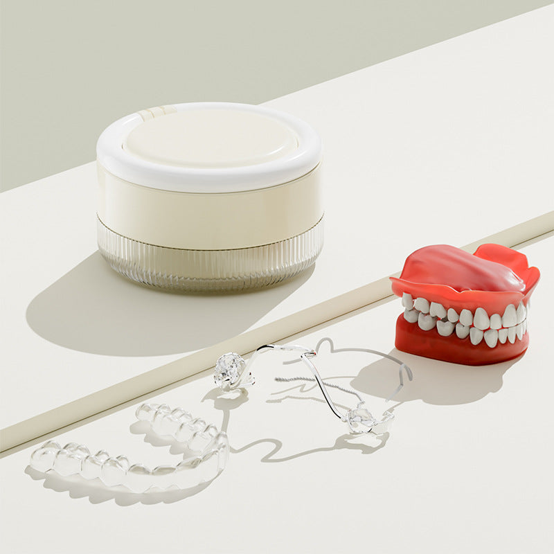 Delunie Cream white soaking case beside removable dental appliances; appliances are not included